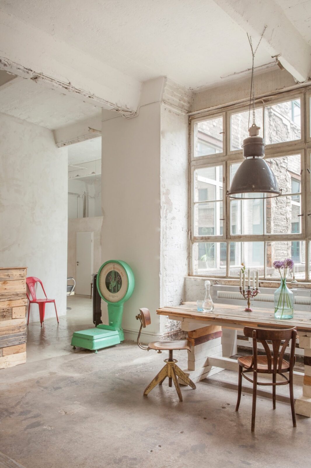 Loft mit Vintage-Waage, Holzmöbeln und Betonboden